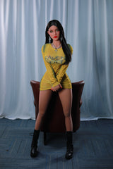 165cm TPE Sex Doll Sienna Full body shot of a woman in a yellow sheer dress and black boots sitting on a brown leather chair facing forward
