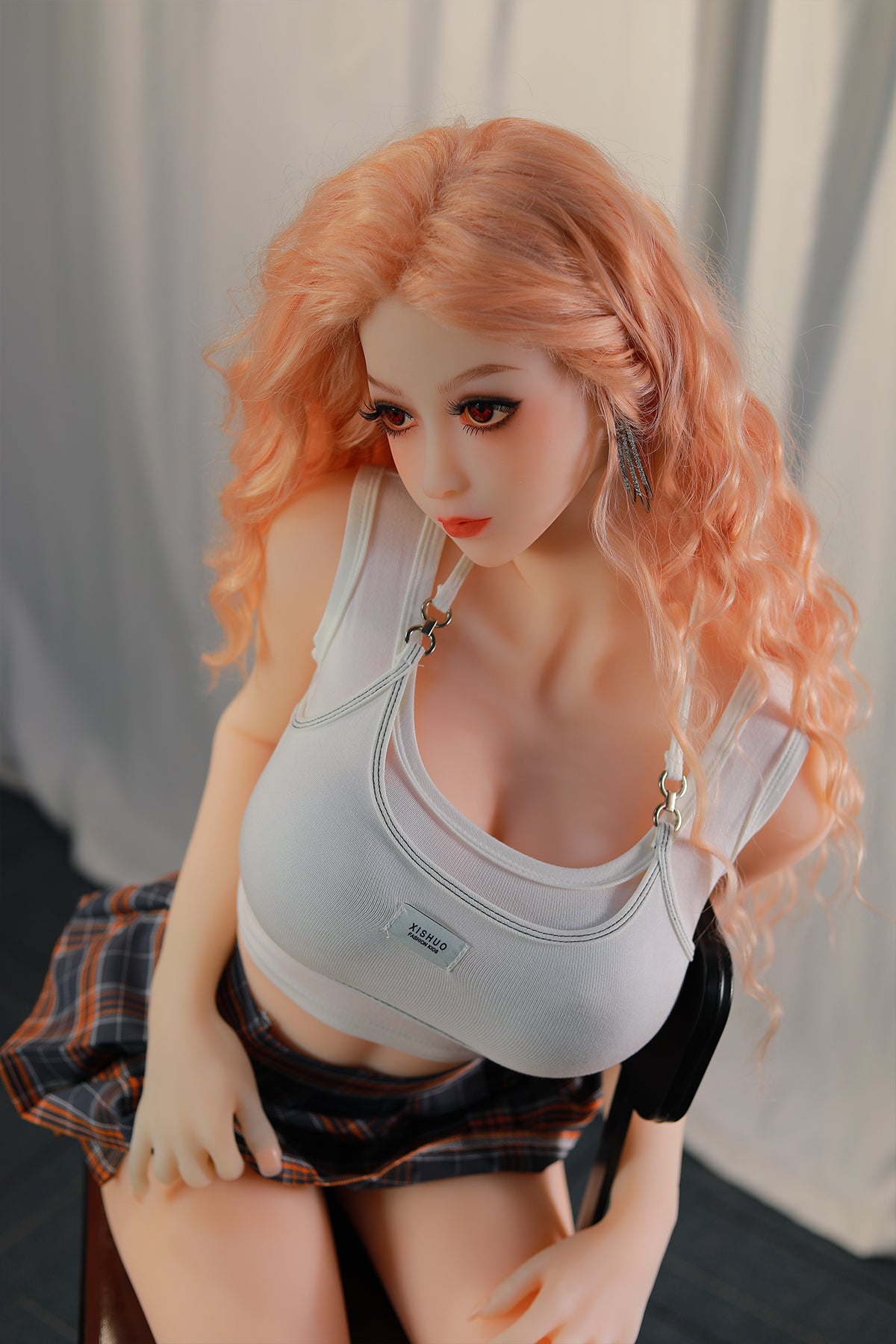 148cm TPE Sex Doll Maya Close-up shot of a doll with peach hair white crop top and plaid skirt looking down and away from the camera