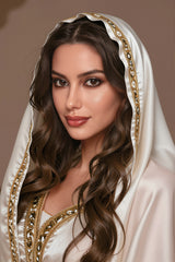 162cm TPE Sex Doll Olive Full-body satin outfit with gold trim headscarf draped over shoulders Seated pose on a bed legs crossed but visible Neutral background clear framing of the
