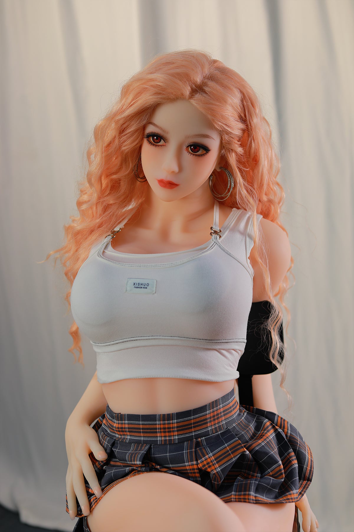 148cm TPE Sex Doll Maya Upper body shot of a doll with peach hair white crop top and plaid skirt leaning against a chair