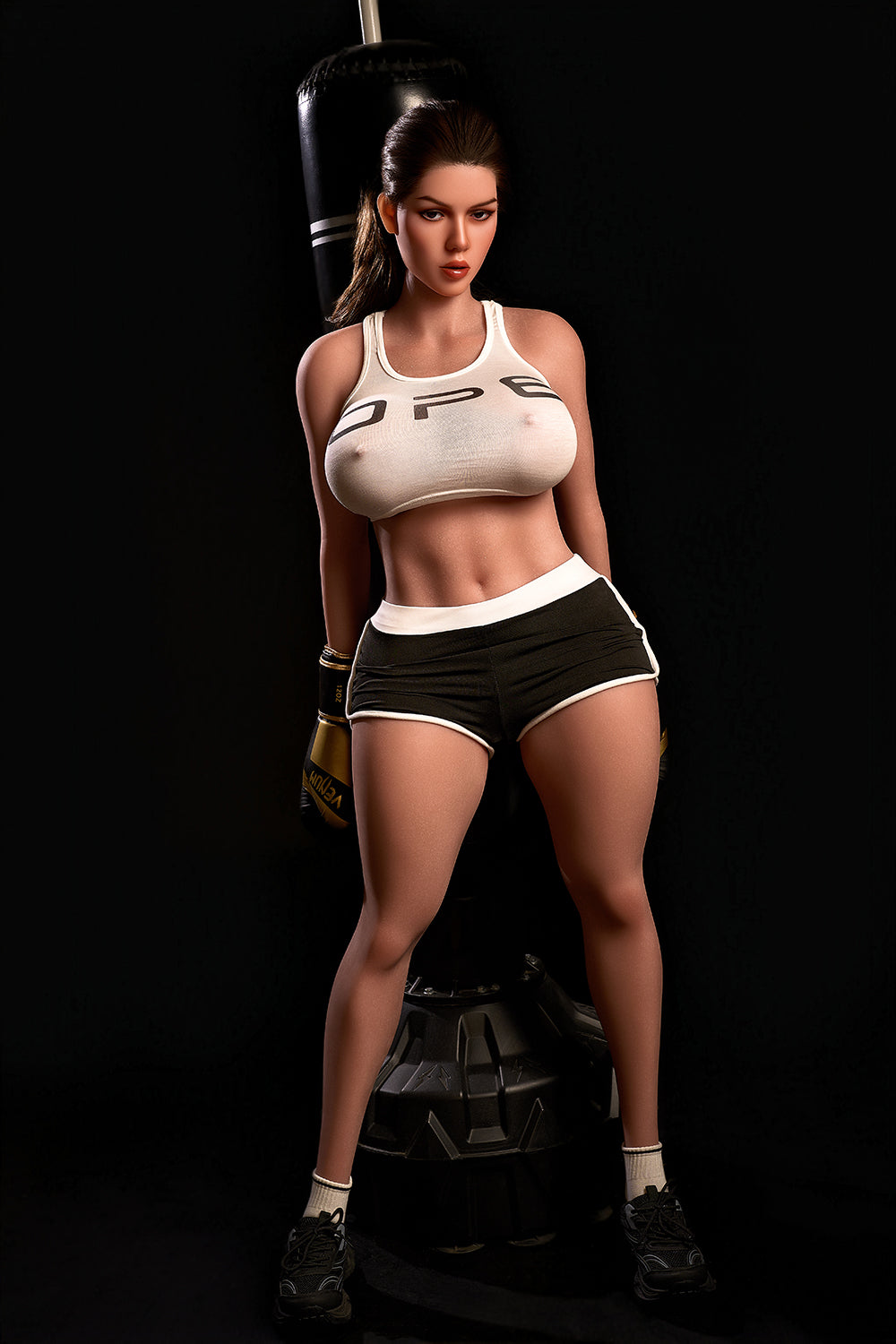 163cm Hybrid Sex Doll Diana Full body shot of woman in white sports bra and black shorts standing by a punching bag