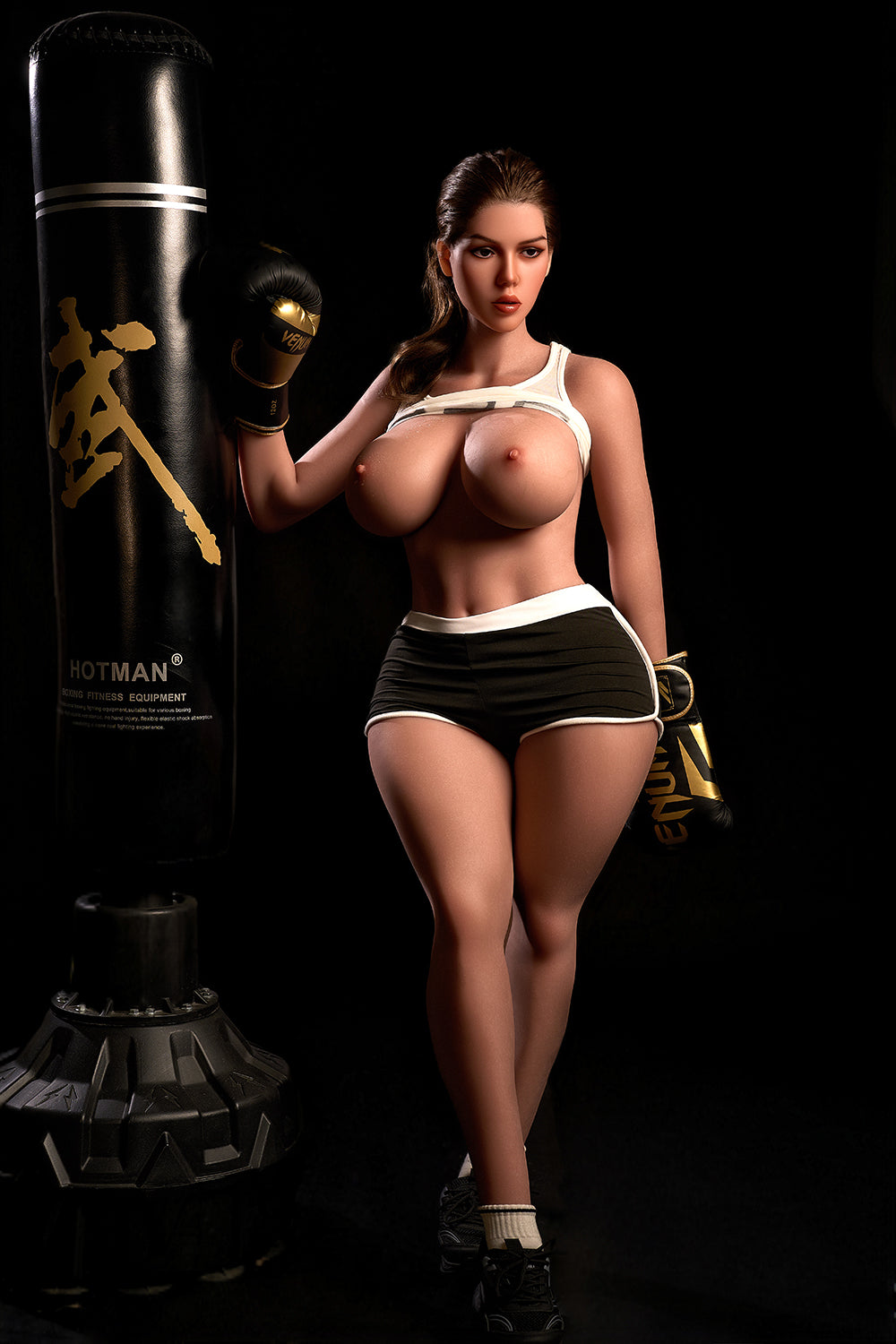 163cm Hybrid Sex Doll Diana Full-body shot of a woman in boxing gear with breasts exposed under a lifted top standing next to a punching bag