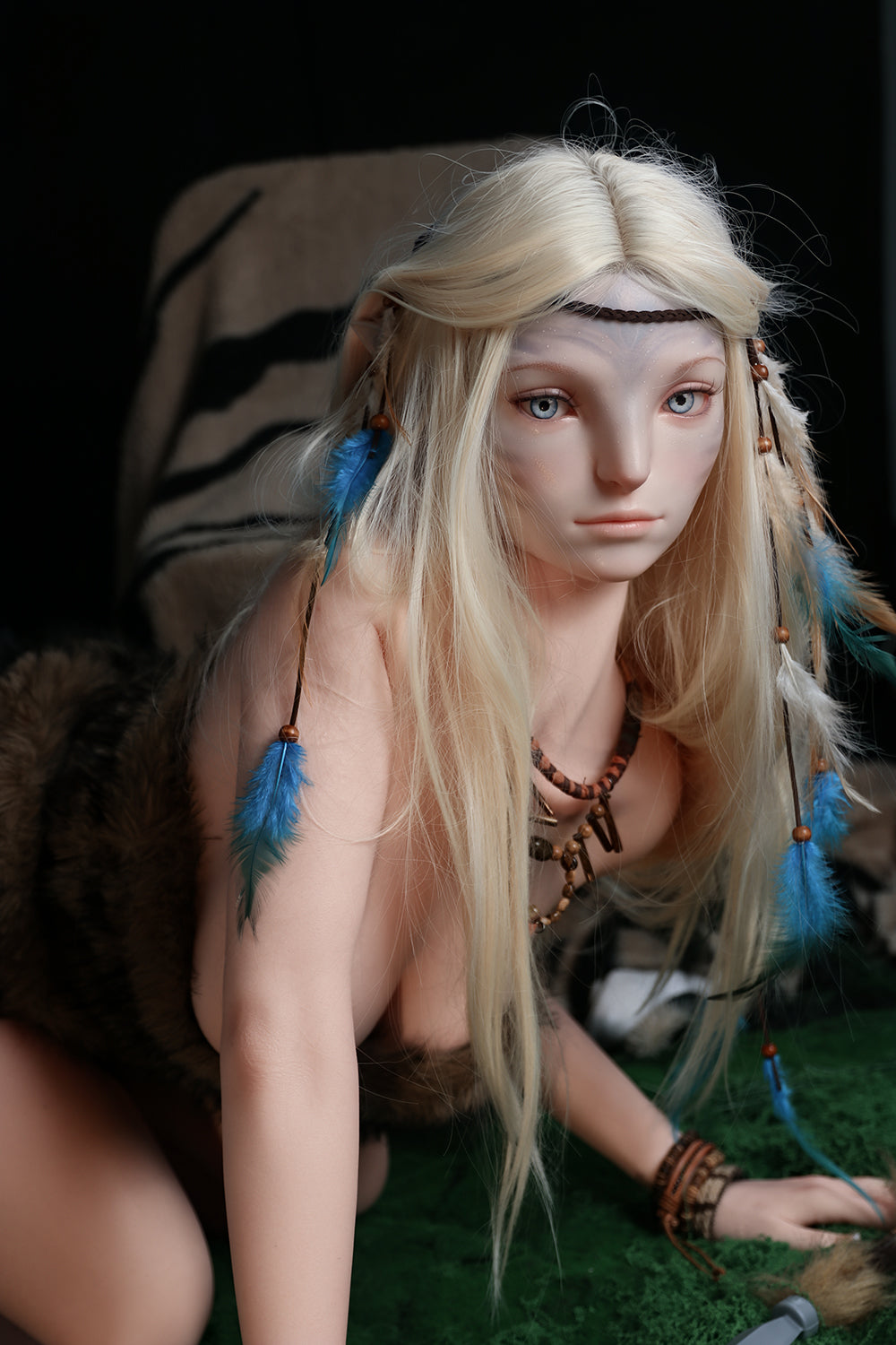 170cm Silicone Sex Doll Madeline Medium close-up portrait of a doll with blonde hair and blue feathers wearing fur clothing against a dark background